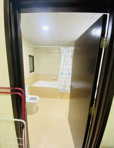 a bathroom with a toilet and a bath tub at Blessing house in Dubai