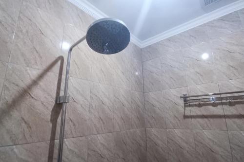 a shower with a shower head in a bathroom at SPOT ON 93376 Roemah Ambarrukma 185 Syariah in Yogyakarta