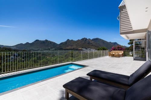 a patio with a swimming pool with mountains in the background at Elite Retreats - Hillside Villa 2 - power backup in Cape Town