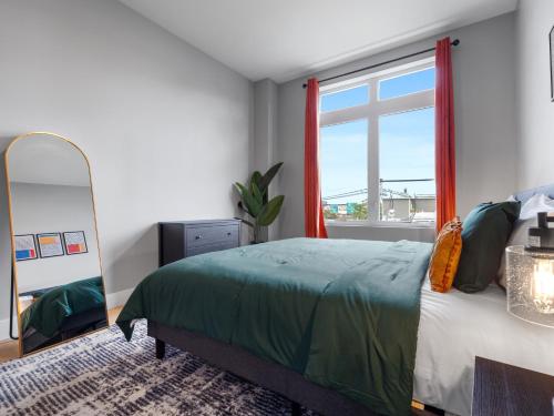 a bedroom with a bed and a large window at Stunning 2BR Condo in Assembly Square East Somerville in Somerville