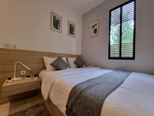 - une chambre avec un grand lit et une fenêtre dans l'établissement OYO Life 93387 Sunarmi House, à Bekasi