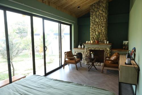 a bedroom with a fireplace and a room with green walls at Anna Little Garden - Homestay Sóc Sơn - Thong House in Hanoi