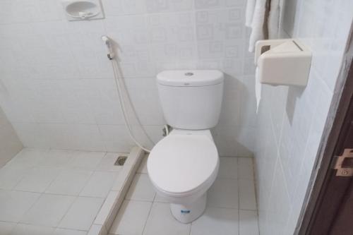 een witte badkamer met een toilet en een douche bij Capital O 93391 Golden Manggis Hotel in Narmada