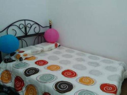 uma cama com um lençol de bolinhas e balões em AD Homestay Kuantan em Kuantan