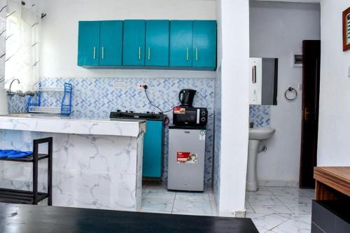 a kitchen with blue cabinets and a refrigerator at Davis Homes in Kitale