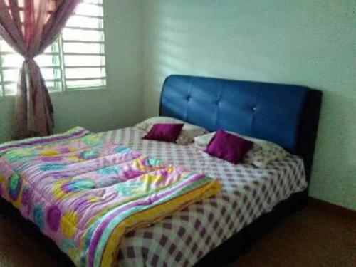 關丹的住宿－AD Homestay Kuantan，卧室里一张带蓝色床头板的床
