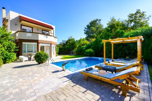 a backyard with a swimming pool and a house at EvMar Villa in Rhodes Town