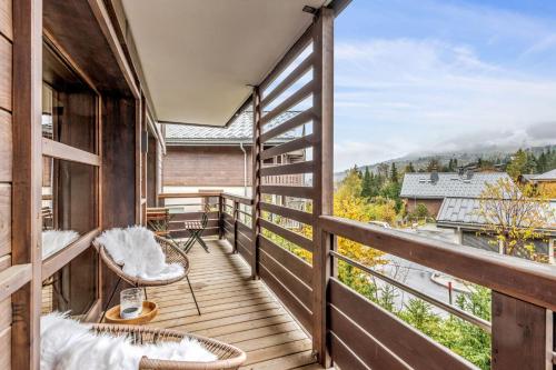 a balcony with chairs and a view of a river at Apartment with relaxation area in Megève - Welkeys in Megève