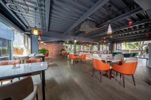 a restaurant with orange chairs and tables in a room at Guangzhou Yunzhu Hotel in Guangzhou