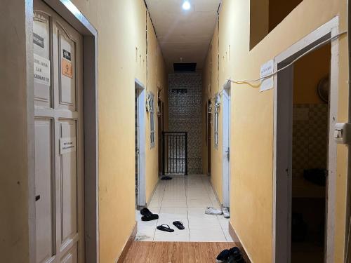 un pasillo vacío con zapatos en el suelo de una habitación en OYO 93412 Kost Irma Syariah, en Parepare