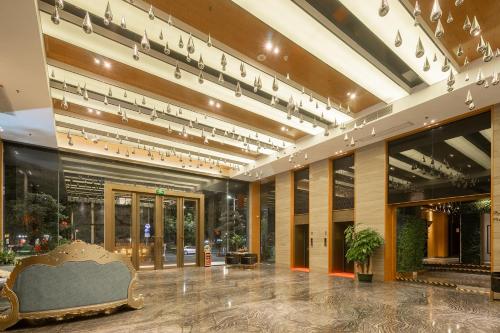 a lobby of a building with a bench in the middle at Guangzhou Yunzhu Hotel in Guangzhou