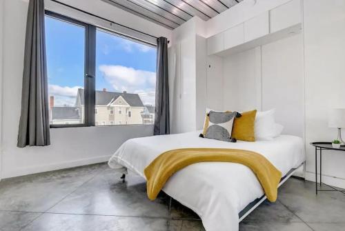 een witte slaapkamer met een groot bed en een groot raam bij KCM Mikros Smart Apartments 3 in Cleveland