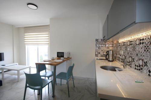 a kitchen with a counter and chairs and a table at Palmea Hotel in Marmaris
