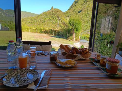 uma mesa com comida e vista para uma montanha em AU JASMIN DE NUIT em La Plaine des Palmistes