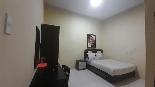 מיטה או מיטות בחדר ב-OYO 93417 Homestay Bunga Rinte Syariah