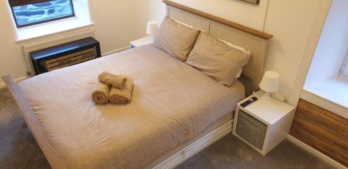 1 dormitorio con 1 cama con 2 toallas en Penbryn Holidays, Barmouth en Barmouth