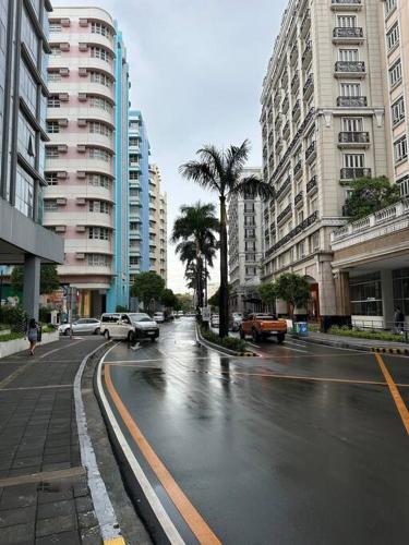 a city street with cars and palm trees and buildings at Airport NAIA Terminal 3 Insane Interior in Manila