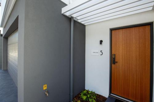 a front door of a building with a wooden door at Kirkland - Pet Friendly - 5 Mins Walk to Beach in Culburra Beach