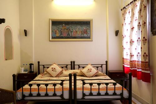 a bedroom with a bed and a painting on the wall at Dev Niwas - Heritage Hotel in Būndi