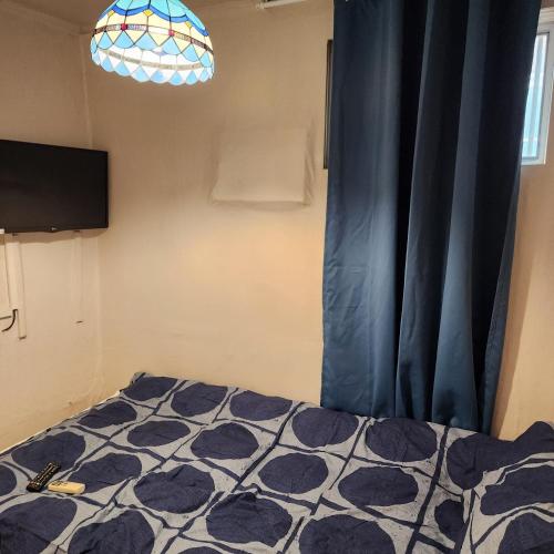 una camera con letto e tenda blu di Hanil Hostel a Seul