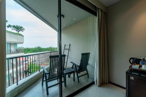 two chairs sitting on a balcony with a view at Tara Mantra Cha-Am Resort in Cha Am