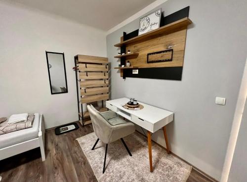 een kleine kamer met een bureau en een bed bij Roomino Apartment in Wenen