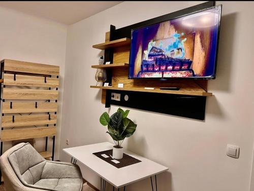 a living room with a flat screen tv on a wall at Roomino Apartment in Vienna