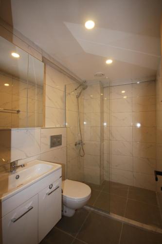 a bathroom with a toilet and a glass shower at Palmea Hotel in Marmaris