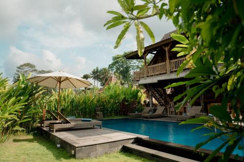 a resort with a swimming pool and an umbrella at Kubu Sakian Villa and Restaurant Sidemen in Silebeng