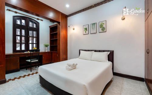 a bedroom with a large white bed and a desk at 5H Garden in Ho Chi Minh City