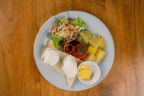 a plate of food on a wooden table at Kubu Sakian Villa and Restaurant Sidemen in Silebeng