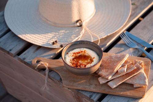 a bowl of dip and a plate of crackers on a table at Hôtel Le Rivage vue sur mer - Châtelaillon-plage in Châtelaillon-Plage