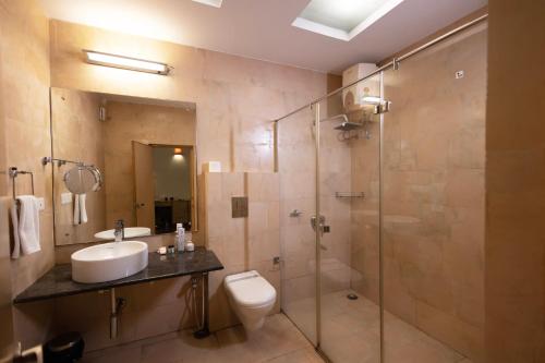 een badkamer met een toilet, een wastafel en een douche bij Classic Boutique Hotel & Luxury Service Apartments in Visakhapatnam