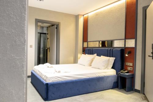 een slaapkamer met een bed met een blauw hoofdeinde bij Voir Hotel Pera in Istanbul