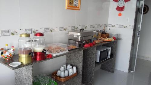 eine Küche mit einer Theke und einer Mikrowelle in der Unterkunft Pousada Porto Sol in Porto De Galinhas