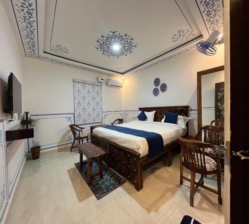 a bedroom with a bed and chairs and a ceiling at Hem Vilas in Sawāi Mādhopur