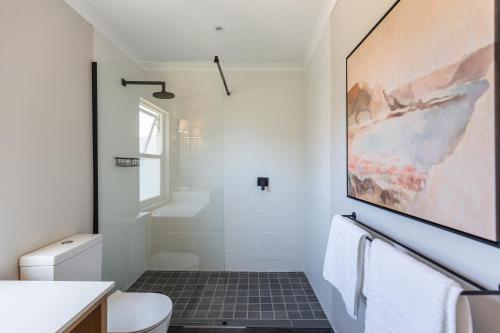 y baño con aseo blanco y lavamanos. en Exclusive Tree Cottage with hot tub - Power Back-up, en Ciudad del Cabo