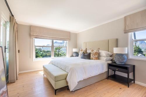 1 dormitorio con 1 cama grande y 2 ventanas en Exclusive Tree Cottage with hot tub - Power Back-up, en Ciudad del Cabo