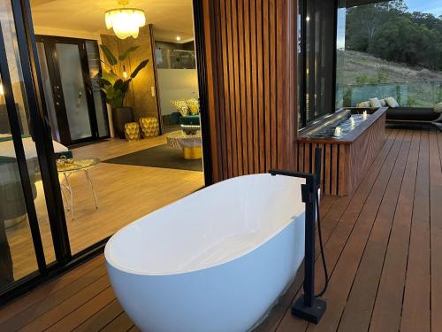 a bath tub sitting on a deck in a house at On Eagle Wings Mountain Retreat & Spa in Neranwood