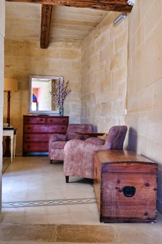 a living room with a couch and a chair at Maria's B&B in Għasri