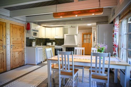eine Küche mit einem Tisch und Stühlen darin in der Unterkunft Rukajärven Lomamajat Apartment 5 in Kuusamo