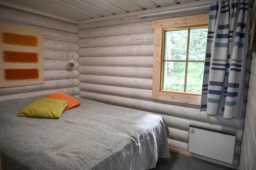 ein kleines Schlafzimmer mit einem Bett und einem Fenster in der Unterkunft Rukajärven Lomamajat Apartment 5 in Kuusamo