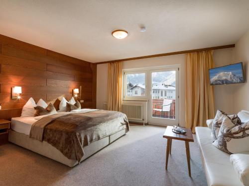 a bedroom with a large bed and a window at MANNI Gästehaus in Mayrhofen