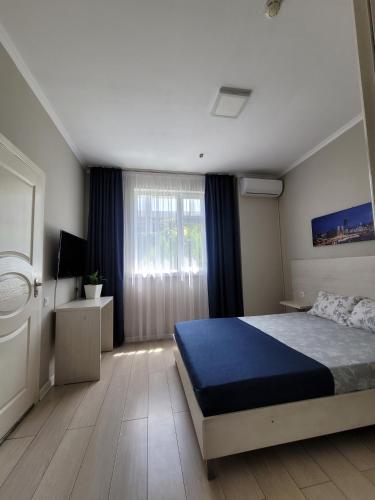 Un dormitorio con una cama grande y una ventana. en Sky hotel KG, en Bishkek