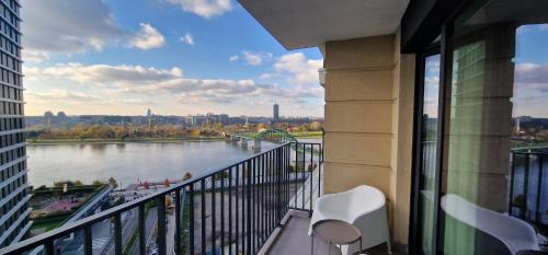 a balcony with two chairs and a view of a river at Beograd na vodi - Belgrade Waterfront Riverside in Belgrade