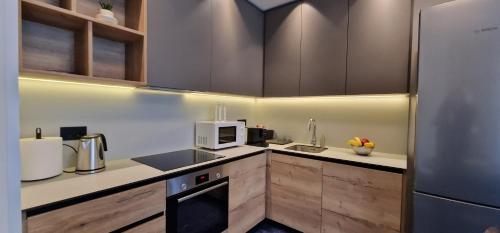 a kitchen with a refrigerator and a microwave at Beograd na vodi - Belgrade Waterfront Riverside in Belgrade