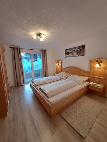 a bedroom with a large bed and a large window at Schalklerhof in Pfunds