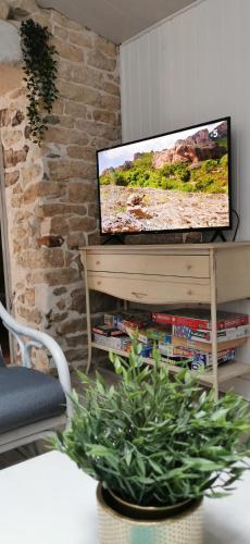 a living room with a television on a table at La Maison du pêcheur - Jacuzzi 3 Etoiles in Jard-sur-Mer