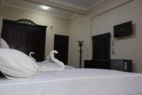 um quarto com uma cama com cisnes em رويال ماجيك no Cairo