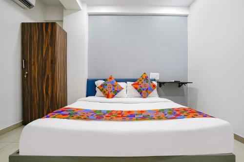 a bedroom with a large bed with colorful pillows at FabExpress Blue Stone in Surat